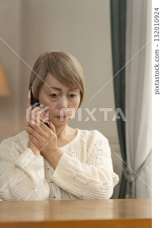 一位老年婦女在家中回應可疑電話 132010924