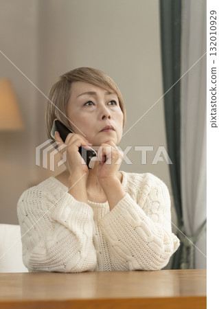 一位老年婦女在家中回應可疑電話 一位老年婦女在家中回應可疑電話 132010929