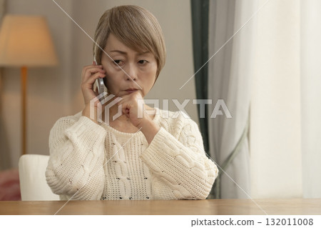 A senior woman responding to a suspicious call on her mobile phone 132011008
