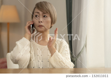 A senior woman responding to a suspicious call on her mobile phone 132011011