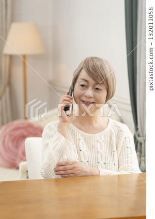 老年婦女在家裡愉快地打電話聊天 老年婦女在家裡愉快地打電話聊天 132011058