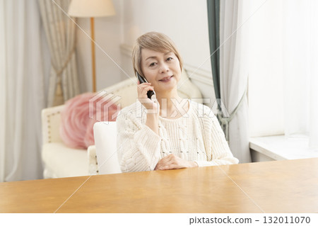 老年婦女在家裡愉快地打電話聊天 老年婦女在家裡愉快地打電話聊天 132011070