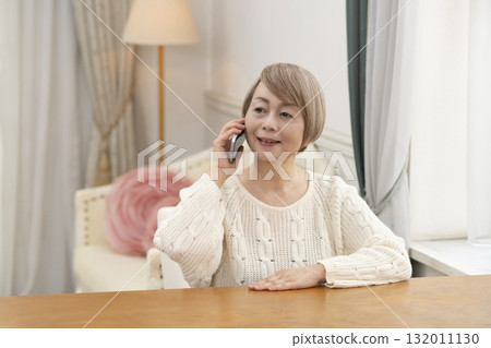老年婦女們愉快地用智慧型手機聊天和搜索 老年婦女們愉快地用智慧型手機聊天和搜索 132011130