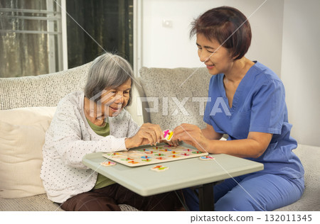 Nurse in nursing home helping a senior woman with number puzzle.  . Dementia, Alzheimer's disease concept 132011345
