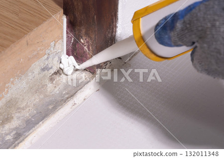 Handyman use acrylic sealant on hole of base door frame for protect underground insects pass through. 132011348