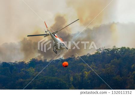 Fire fighting helicopter carry watethar bucket to extinguish the forest fire. Fire fighting helicopter carry watethar bucket to extinguish the forest fire. 132011352