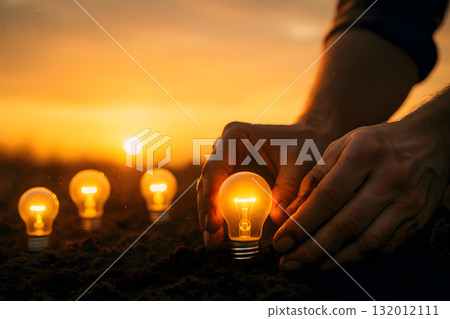 Close-up of hand planting a fluorescent light bulb in soil. Empty space above to place as headline. Concept of knowledge as the seed of success. 132012111