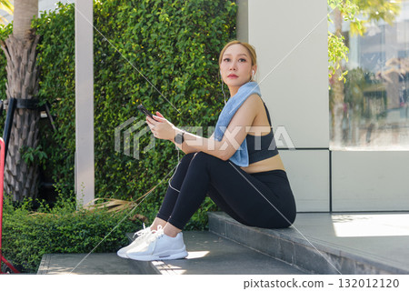 Fit woman enjoys outdoor sport exercise workout, people observe her dedication health fitness staying fit wearing activewear listening music urban green setting quiet moment. 132012120