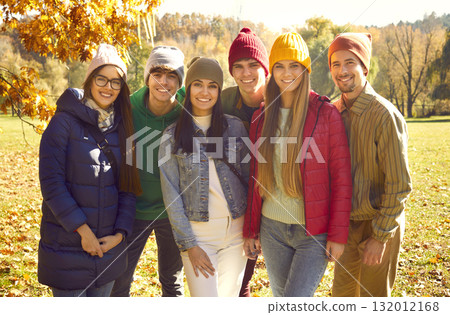 Group portrait of happy cheerful young friends standing together in sunny autumn park Group portrait of happy cheerful young friends standing together in sunny autumn park 132012168