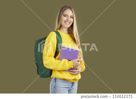 Portrait of happy student girl with green backpack and copybooks on khaki background. Portrait of happy student girl with green backpack and copybooks on khaki background. 132012171