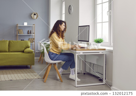 Young business woman accountant working on a laptop with tables at office. Young business woman accountant working on a laptop with tables at office. 132012175