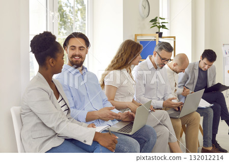 Diverse people communicate with each other during business training in office of business center. 132012214