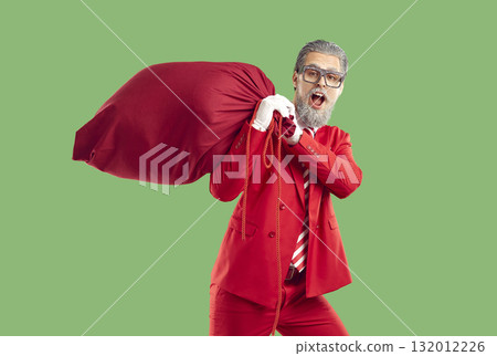 Cool man in image of stylish modern Santa Claus delivers Christmas presents carrying heavy red bag. 132012226