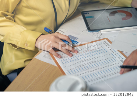 Business colleagues pointing at business document during discussion at meeting. Business people meeting explaining the financial graph data and marketing plan.Teamwork process. Business colleagues pointing at business document during discussion at meeting. Business people meeting explaining the financial graph data and marketing plan.Teamwork process. 132012942