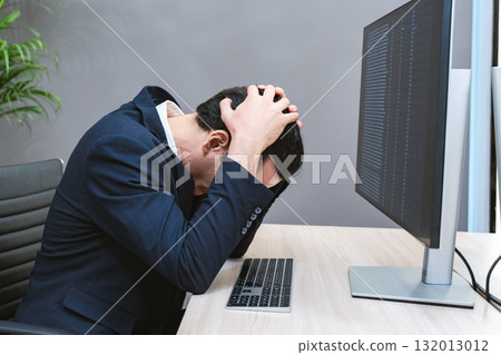 Young Businessman or Programmer looking worried and stressed over working on a computer code at office. 132013012