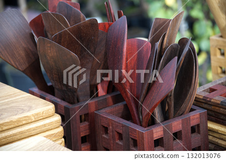 Wooden kitchen utensils displayed in decorative holders, perfect for culinary use. Wooden kitchen utensils displayed in decorative holders, perfect for culinary use. 132013076