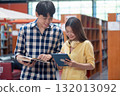 Young Asian students using laptop, learning and discussing in a library at the university. 132013092