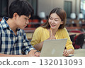 Young Asian students using laptop, learning and discussing in a library at the university. 132013093