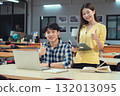 Young Asian students using laptop, learning and discussing in a library at the university. 132013095