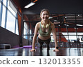 Young Asian woman performing push-ups from the floor in the gym. 132013355