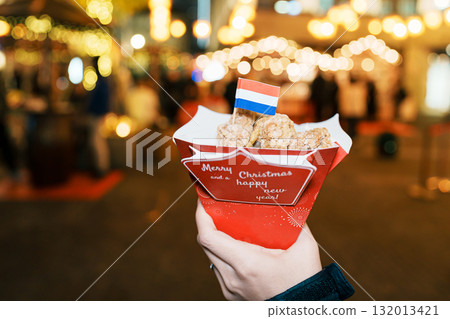 Woman eating Christmas food with snack and sausage at German Christmas market. Merry Christmas and happy New Year concept Woman eating Christmas food with snack and sausage at German Christmas market. Merry Christmas and happy New Year concept 132013421
