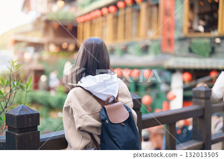 woman traveler visiting in Taiwan, female Tourist with backpack sightseeing at Jiufen Old Street village with Tea House background. Popular landmarks and attractions near Taipei City. Travel concept 132013505