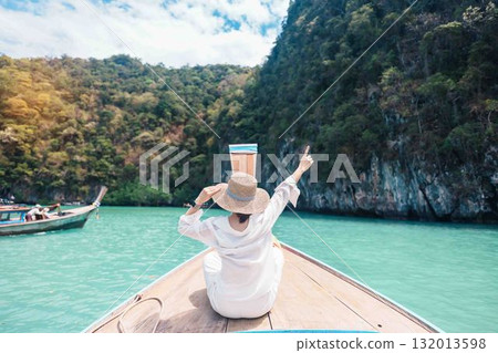 Happy Woman tourist in private longtail boat trip to koh Hong lagoon island at Krabi, Thailand. landmark, tropical destination, southeast Asia Travel, summer vacation, wanderlust and holiday concept Happy Woman tourist in private longtail boat trip to koh Hong lagoon island at Krabi, Thailand. landmark, tropical destination, southeast Asia Travel, summer vacation, wanderlust and holiday concept 132013598