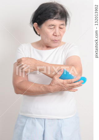 Elderly Woman having elbow ache and Edema with Cold Gel pack  for concepts of Tennis Elbow, muscle pain and Sprain, lateral epicondylitis, Bursitis, injury, Senior Health care and medical 132013902