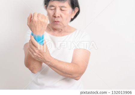Elderly Woman having wrist pain and Edema with Cold Gel pack for Carpal Tunnel Syndrome, Wrist Tendinitis, muscle ache, De Quervain s tenosynovitis, Hand Osteoarthritis and Senior health care concept 132013906