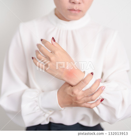 Woman having wrist pain with Medicated pain relief patch plaster for Carpal Tunnel Syndrome, Wrist Tendinitis ache, De Quervain s tenosynovitis, ergonomic, Hand Osteoarthritis and Office syndrome 132013913