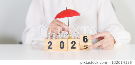 Happy New Year 2026 with hand holding red umbrella cover people chess. life Insurance, health medical, leadership, protection, safety and New year holiday Concepts 132014156