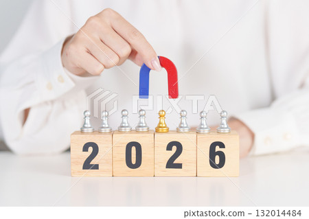 hand holding magnet and pulling man chess figure from the crowd employee with 2026 Year block. Human resource management, Recruitment, Teamwork, strategy, toxic people and leadership Concepts 132014484