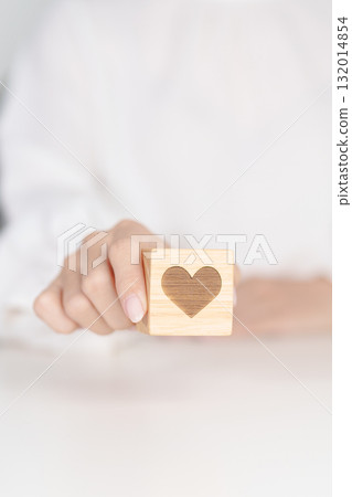 Hand holding heart block for health care, love, organ donation, charity, happy family, wellbeing and insurance concepts. world heart day, health day and mental health day Hand holding heart block for health care, love, organ donation, charity, happy family, wellbeing and insurance concepts. world heart day, health day and mental health day 132014854