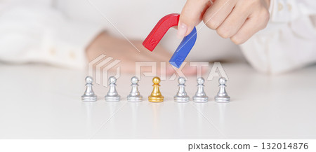 Hand use magnet pulling to golden chess pawn pieces or leader businessman stand out of crowd people of silver men. leadership, business, team, teamwork, unique and Human resource management concept 132014876