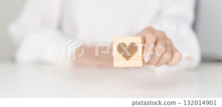 Hand holding heart block for health care, love, organ donation, charity, happy family, wellbeing and insurance concepts. world heart day, health day and mental health day Hand holding heart block for health care, love, organ donation, charity, happy family, wellbeing and insurance concepts. world heart day, health day and mental health day 132014901