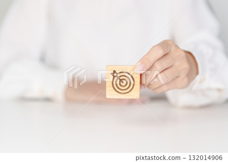 hand hold dartboard block with business goal, strategy, target, mission, action, objective, aim and success concept 132014906