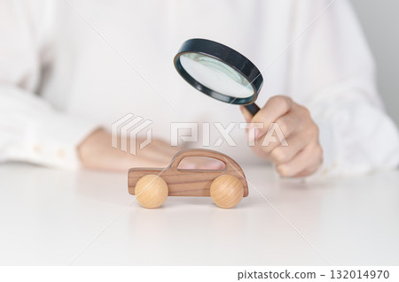 Hand hold magnifying glass over car model. Car loan, Vehicle Inspection, Searching for Automobile, insurance, repair, warranty, purchase and rental car concept Hand hold magnifying glass over car model. Car loan, Vehicle Inspection, Searching for Automobile, insurance, repair, warranty, purchase and rental car concept 132014970