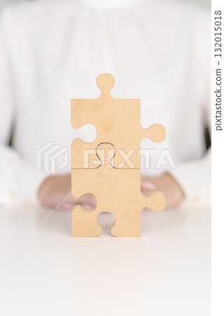 Woman connecting couple puzzle piece, wood jigsaw on table. Business solutions, mission, success, goals, strategy, Teamwork, Idea, Solution and challenge concepts Woman connecting couple puzzle piece, wood jigsaw on table. Business solutions, mission, success, goals, strategy, Teamwork, Idea, Solution and challenge concepts 132015018