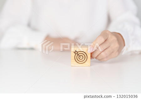 hand hold dartboard block with business goal, strategy, target, mission, action, objective, aim and success concept 132015036