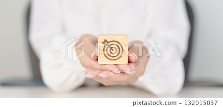 hand hold dartboard block with business goal, strategy, target, mission, action, objective, aim and success concept 132015037
