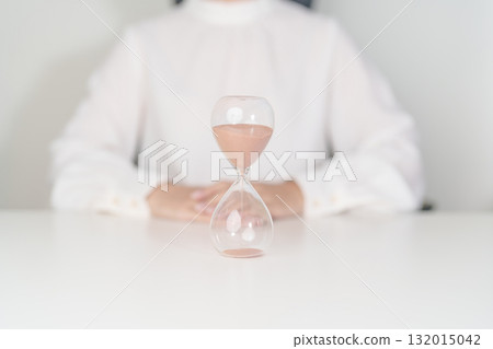 Woman with Hourglass on table office, Sand flowing through the bulb of Sandglass measuring the passing time. countdown, deadline, Life time and Retirement concept 132015042