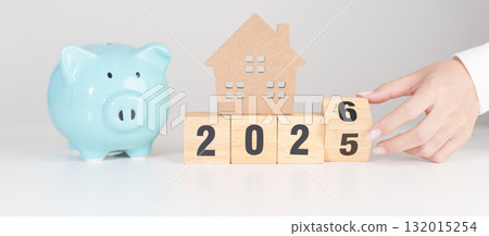 Happy New Year 2026 with house model and Coins stack. real estate, Home loan, tax, investment, mortgage, financial, savings and New Year Resolution concepts 132015254