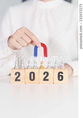 hand holding magnet and pulling man chess figure from the crowd employee with 2026 Year block. Human resource management, Recruitment, Teamwork, strategy, toxic people and leadership Concepts 132015273