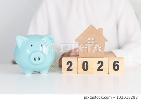 Happy New Year 2026 with house model and Coins stack. real estate, Home loan, tax, investment, mortgage, financial, savings and New Year Resolution concepts 132015288