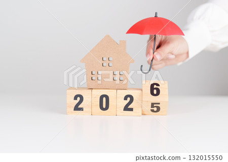 Happy New Year 2026 with red umbrella over money stack. Insurance, real estate, Home loan, tax, investment, mortgage, financial, savings, protection and safety 132015550