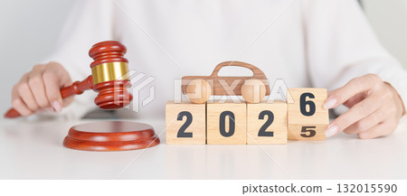 2025 end year to Happy New Year 2026 with small toy car models and Judges gavel on desk in courthouse. Car Law, Insurance, auto Tax, Auction and Bidding concepts 132015590