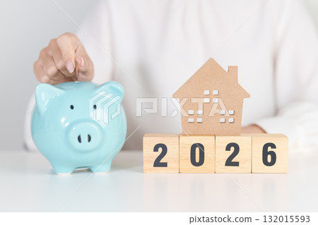 Happy New Year 2026 with house model and Coins stack. real estate, Home loan, tax, investment, mortgage, financial, savings and New Year Resolution concepts 132015593