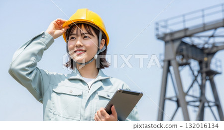 Woman in a helmet working in heavy industry 132016134