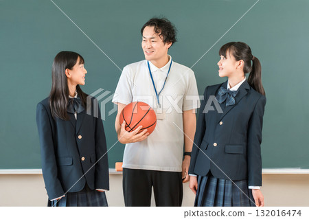 教室裡，黑板前，一位男老師拿著籃球，一位女學生穿著西裝 132016474