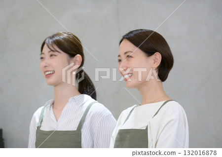 Smiling Japanese women waiting in line at the reception desk Smiling Japanese women waiting in line at the reception desk 132016878